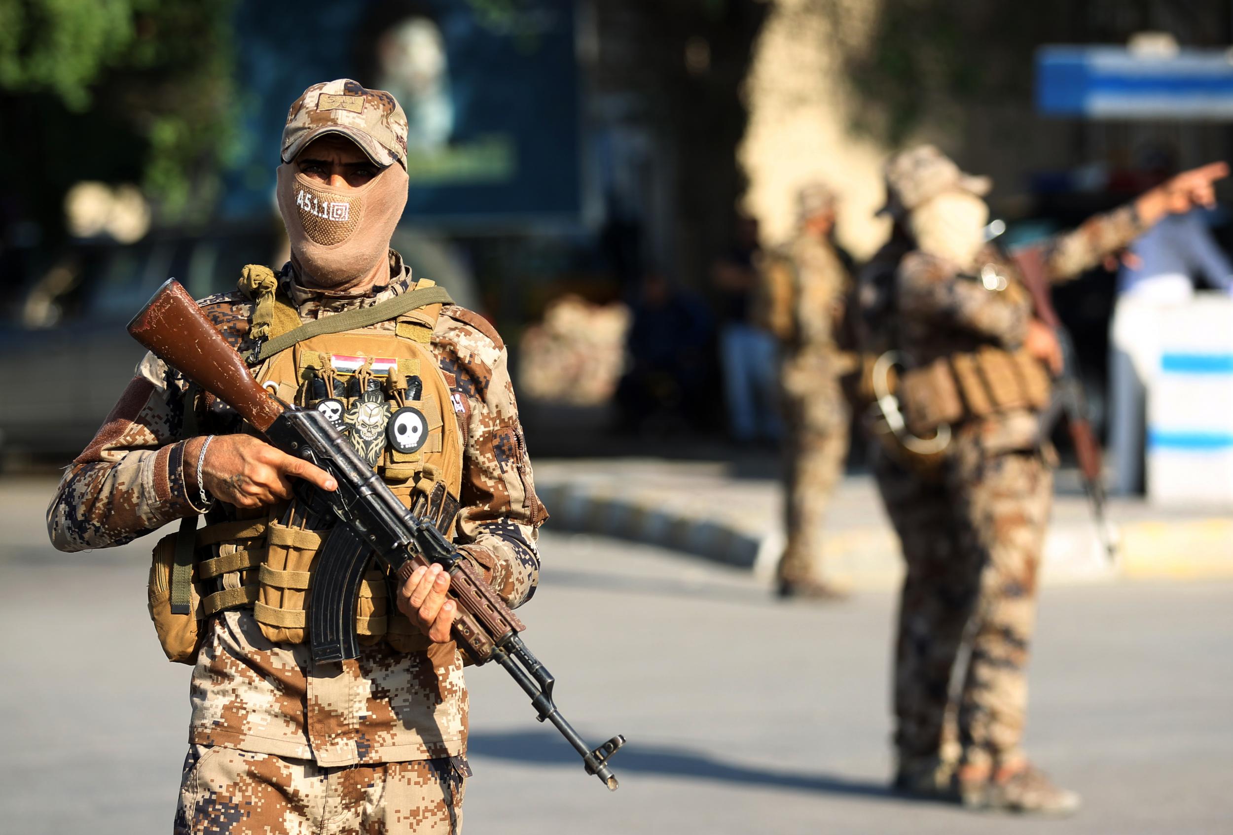 Members of the Hashed al-Shaabi, or Popular Mobilisation Forces (PMF), paramilitaries stand guard during a funerary procession for Wissam Alyawi, a leading commander of the Asaib Ahl Al-Haq faction that is part of the PMF, in the Iraqi capital Baghdad on October 26, 2019