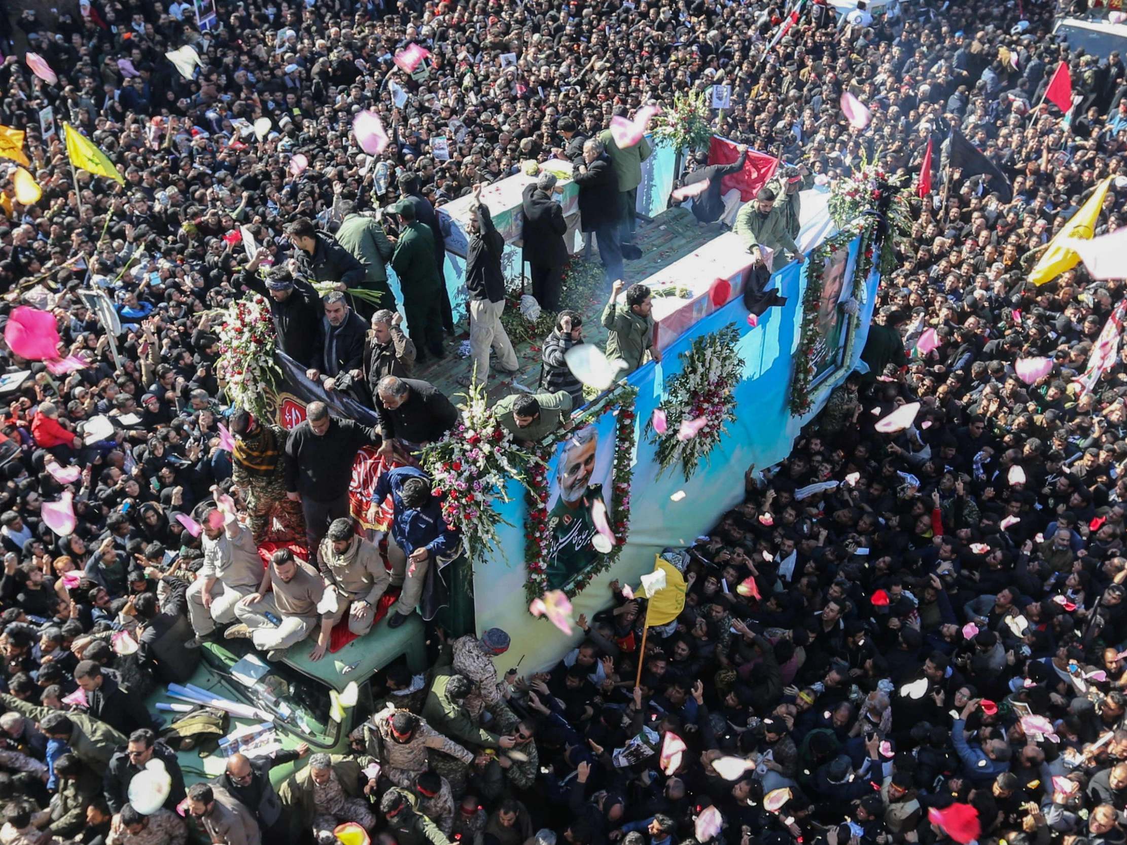 Iranian mourners gather around a vehicle carrying the coffin of slain top general Qasem Soleimani during the final stage of funeral processions