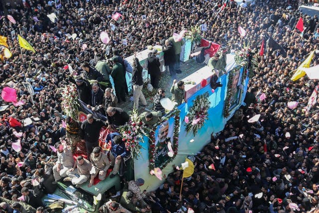 Iranian mourners gather around a vehicle carrying the coffin of slain top general Qasem Soleimani during the final stage of funeral processions