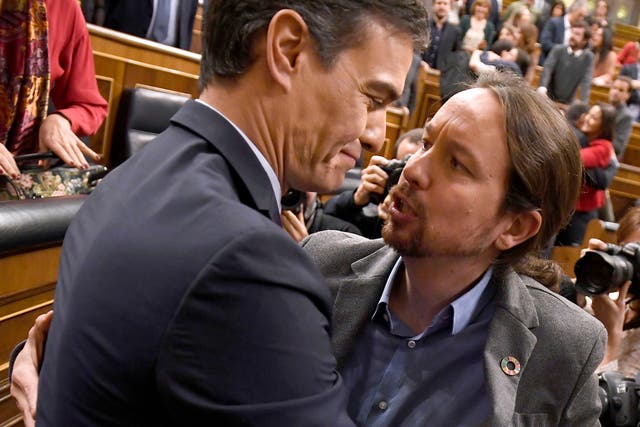 PSOE leader Pedro Sanchez is congratulated by Spanish left-wing Unidas Podemos leader Pablo Iglesias
