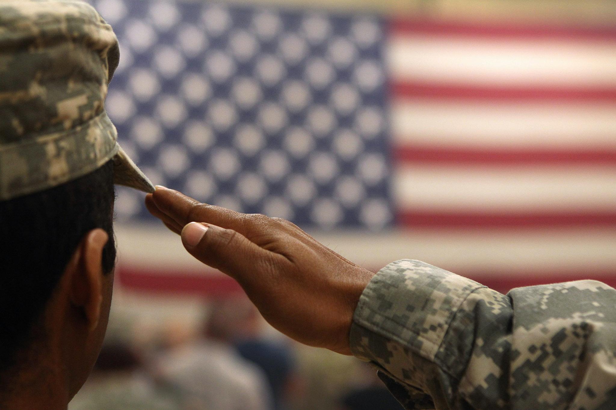 A soldier salutes the flag during a welcome home ceremony for troops arriving from Afghanistan on June 15, 2011 to Fort Carson, Colorado
