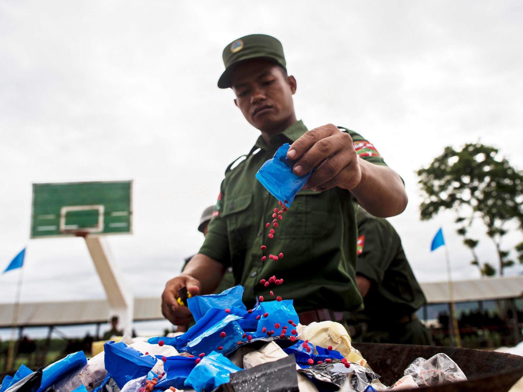 A soldier in Myanmar empties a packet of yaba pills before burning them to mark the UN’s world anti-drugs day