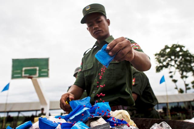 A soldier in Myanmar empties a packet of yaba pills before burning them to mark the UN’s world anti-drugs day