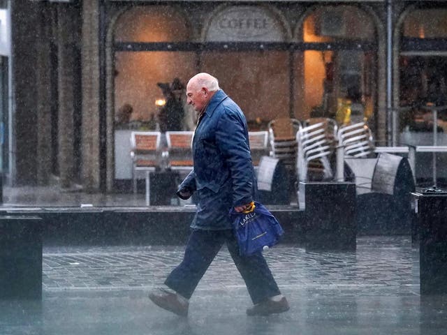 Members of the public make their way through a rain shower in Helensburgh, Scotland