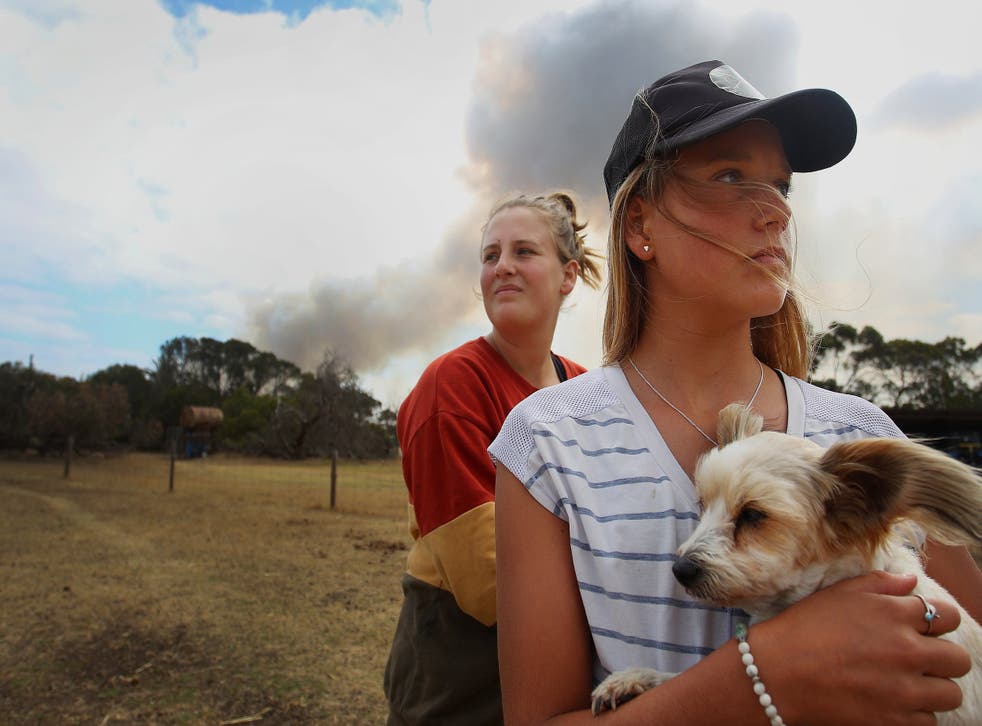 Bonnie Morris and sister Raemi Morris look on as their family and CFS firefighters battle bushfires at the edge of their family farm in Karatta, on Saturday