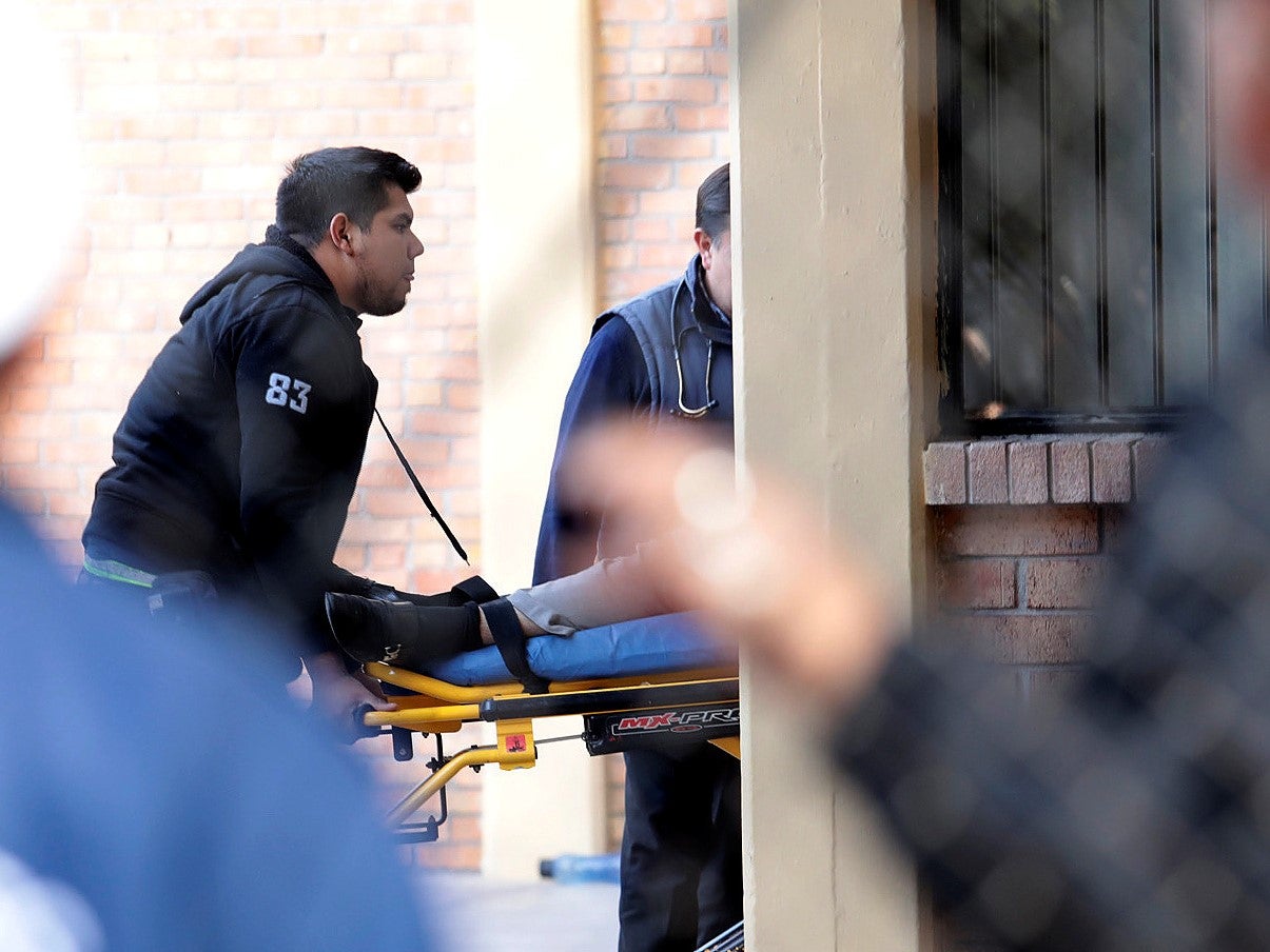 A paramedic wheels a stretcher out of the school after the deadly shooting
