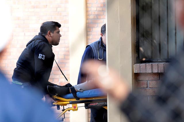 A paramedic wheels a stretcher out of the school after the deadly shooting