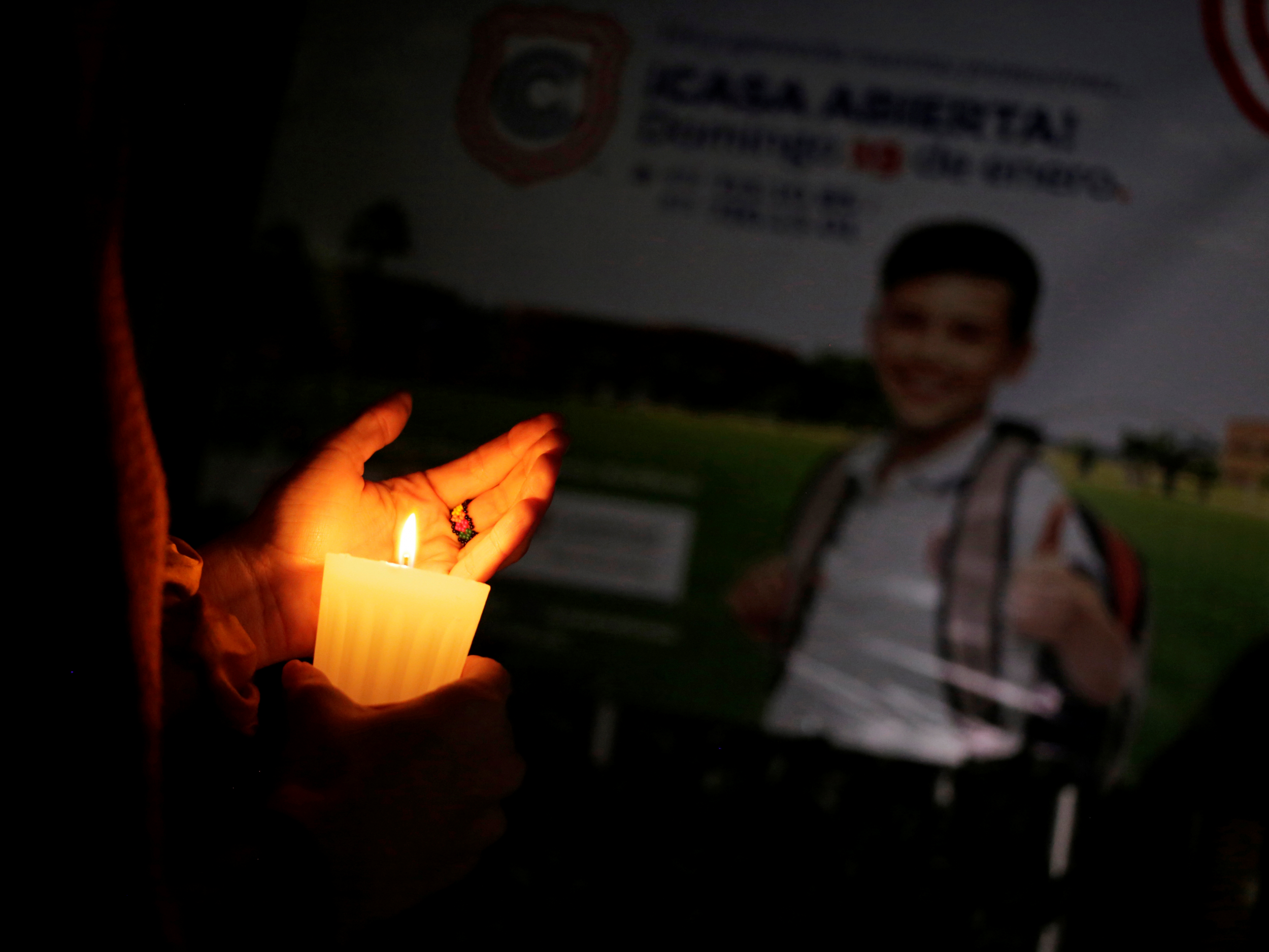 A candle is lit during a vigil outside the school in Torreon