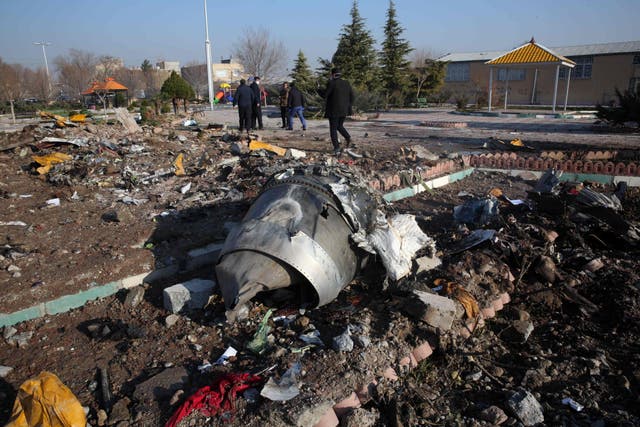 Rescue teams work amidst debris after a Ukrainian plane carrying 176 passengers crashed