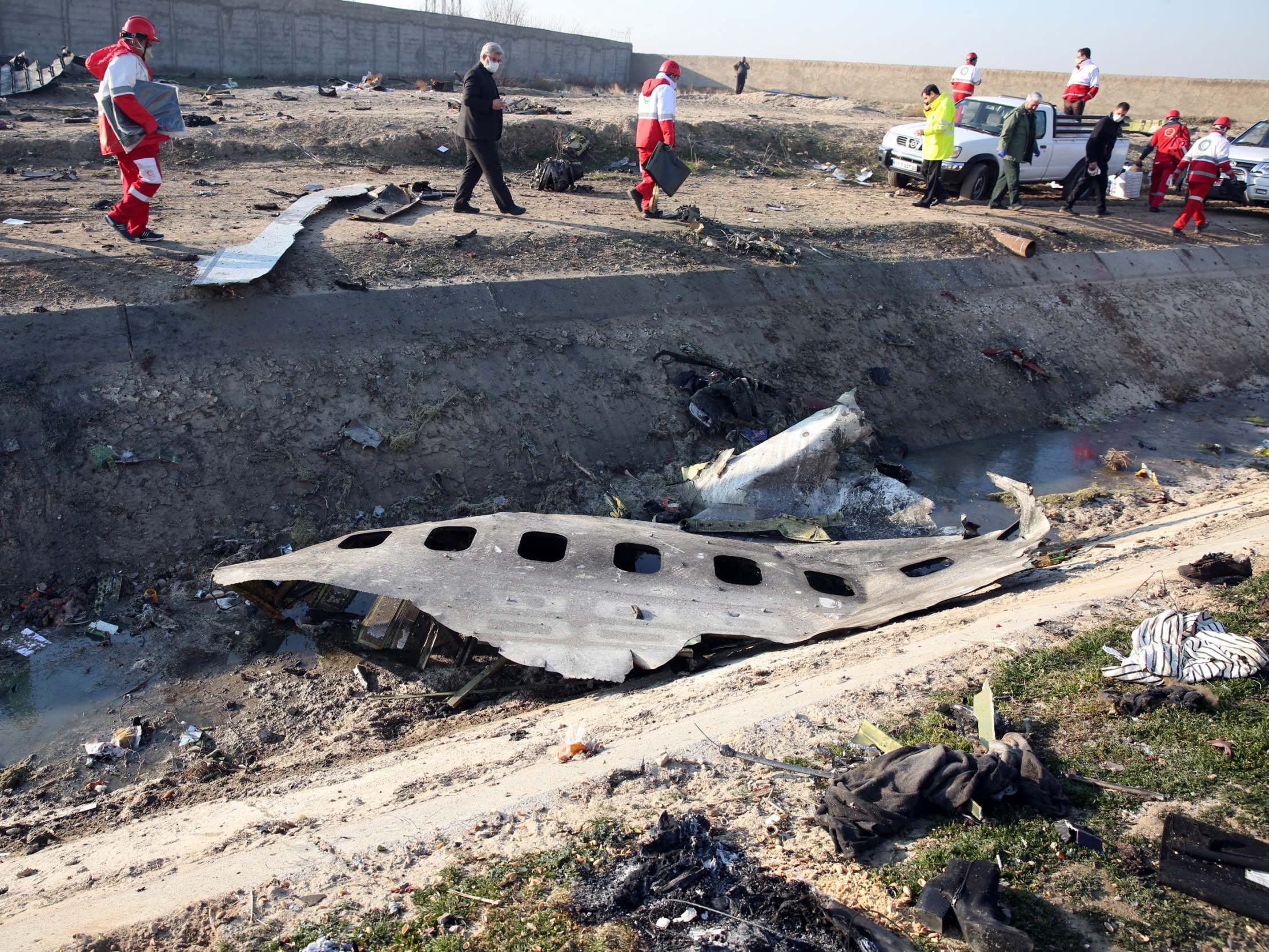 Officials stand near the wreckage of a Ukraine International Airlines Boeing 737-800 near Tehran after a crash that killed 176