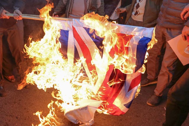 Iranian demonstrators set alight a Union Jack in front of the British embassy in Iran's capital Tehran following the British ambassador's arrest for allegedly attending an illegal demonstration, 12 January, 2020.