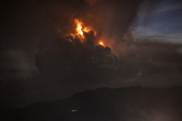 A column of ash surrounds the crater of Taal Volcano as it erupts on Sunday