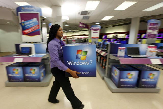 A computer store employee carries promotional signage for Microsoft's new operating system 'Windows 7' ahead of its official launch at midnight tonight on October 21, 2009 in London, England