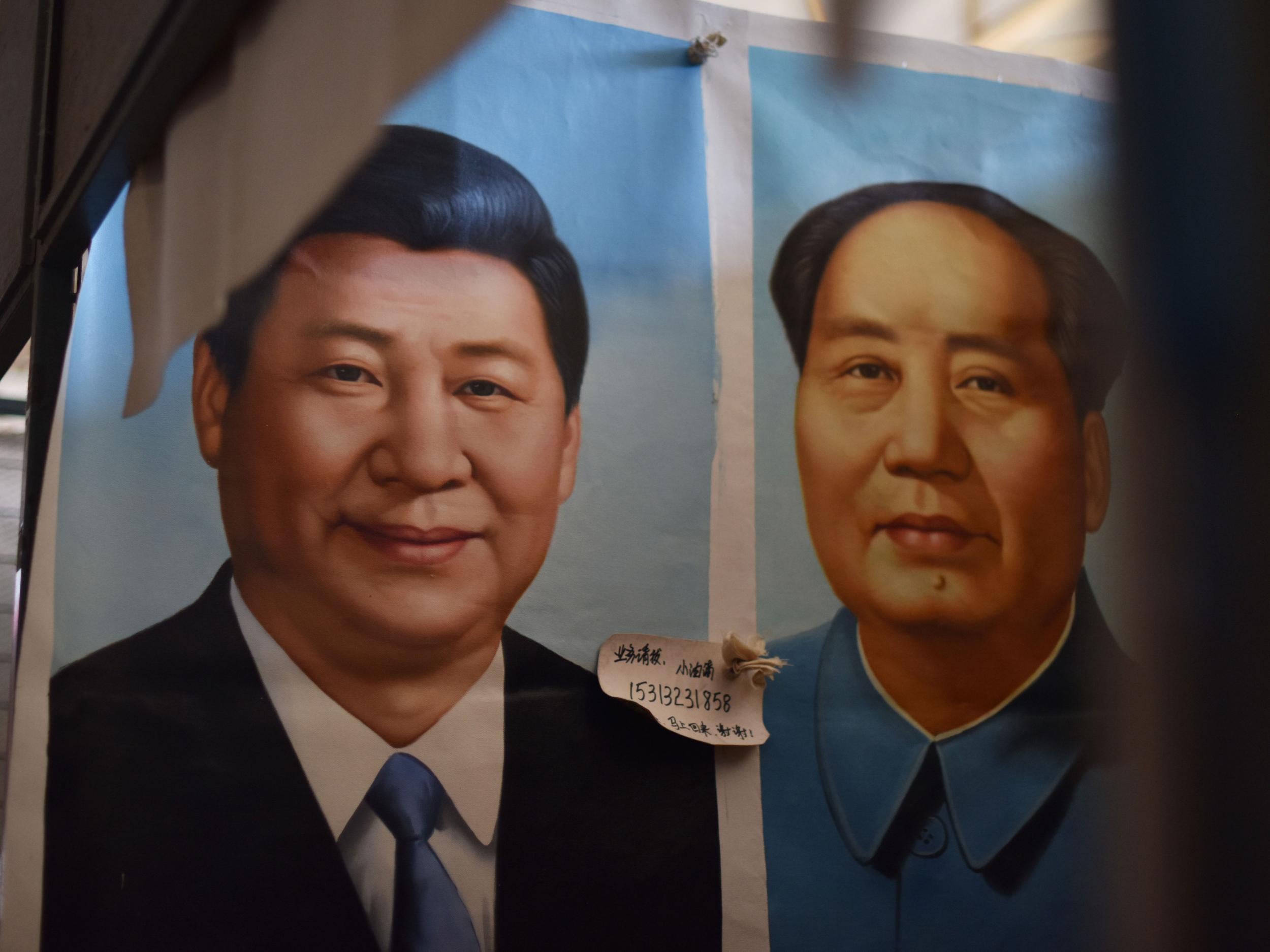 In a Beijing marketplace, a portrait of Xi hangs next to Mao's