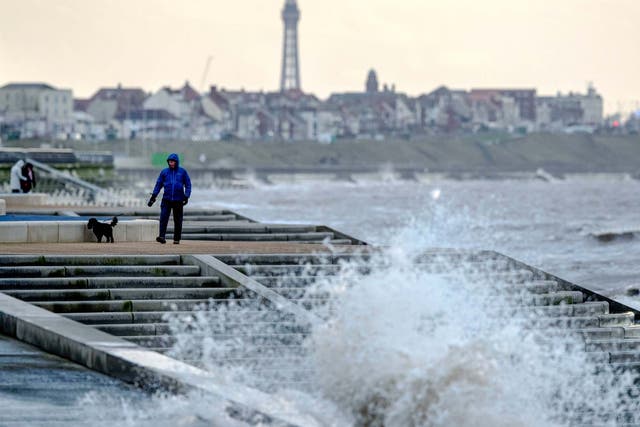 A man walks his dog along the promenade near Blackpool as Storm Brendan causes 80mph gusts hit parts of the UK, 13 January, 2020.