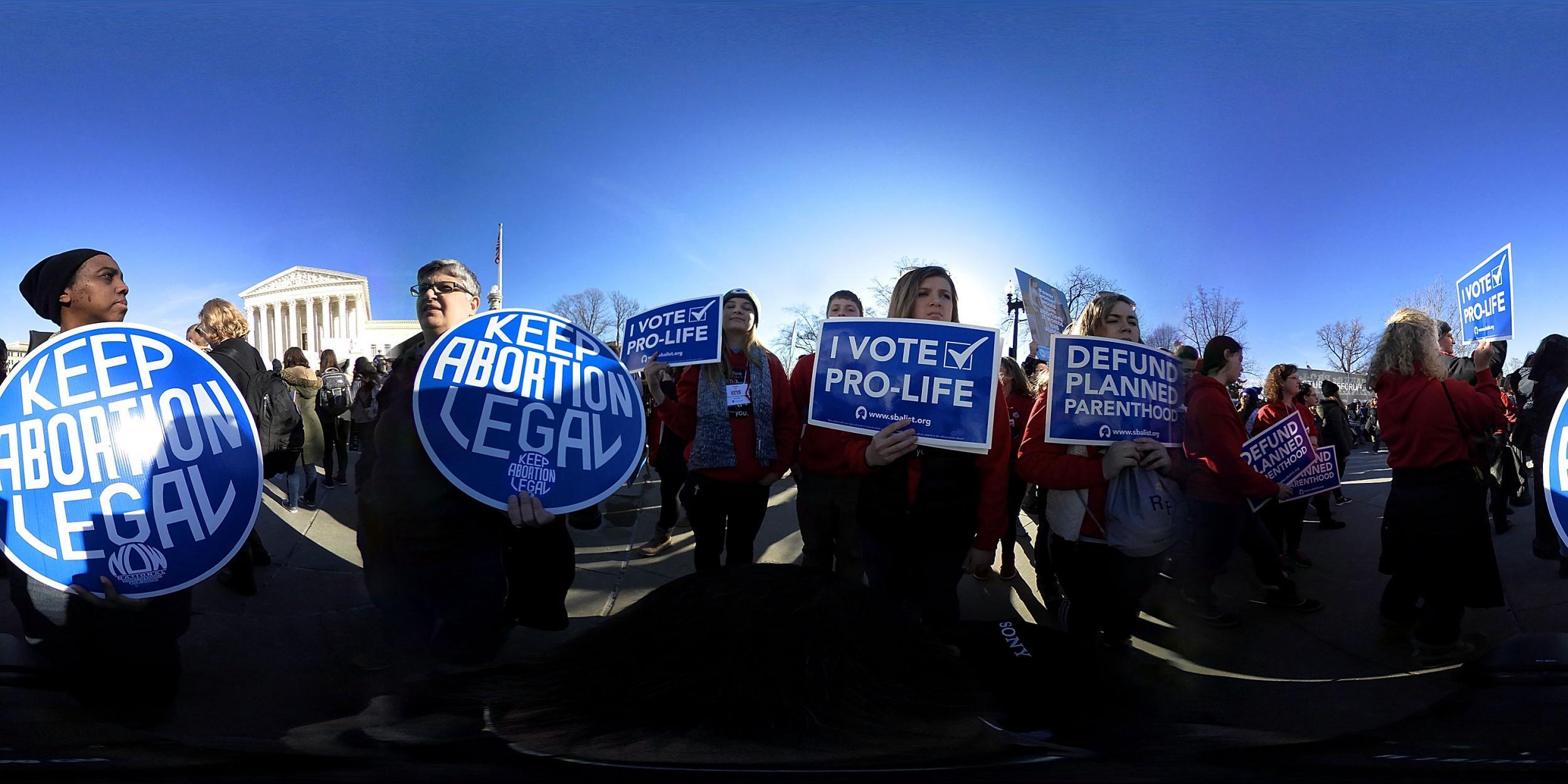 Anti-abortion activists hold signs as they counter-protest in front of the U.S. Supreme Court during the 2018 March for Life January 19 2018 in Washington DC