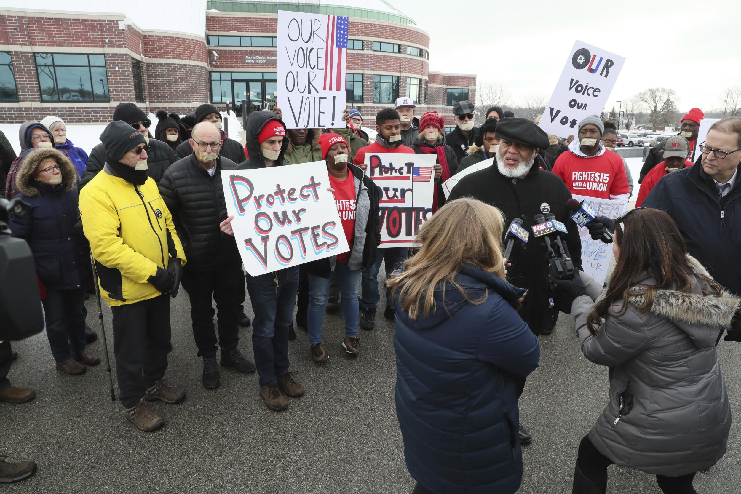 Gregory Lewis, leader of Souls to the Polls, led a protest outside the Ozaukee County Courthouse in Port Washington, Wisconsin on Monday as a local judge ordered a mass voter roll purge to take effect.