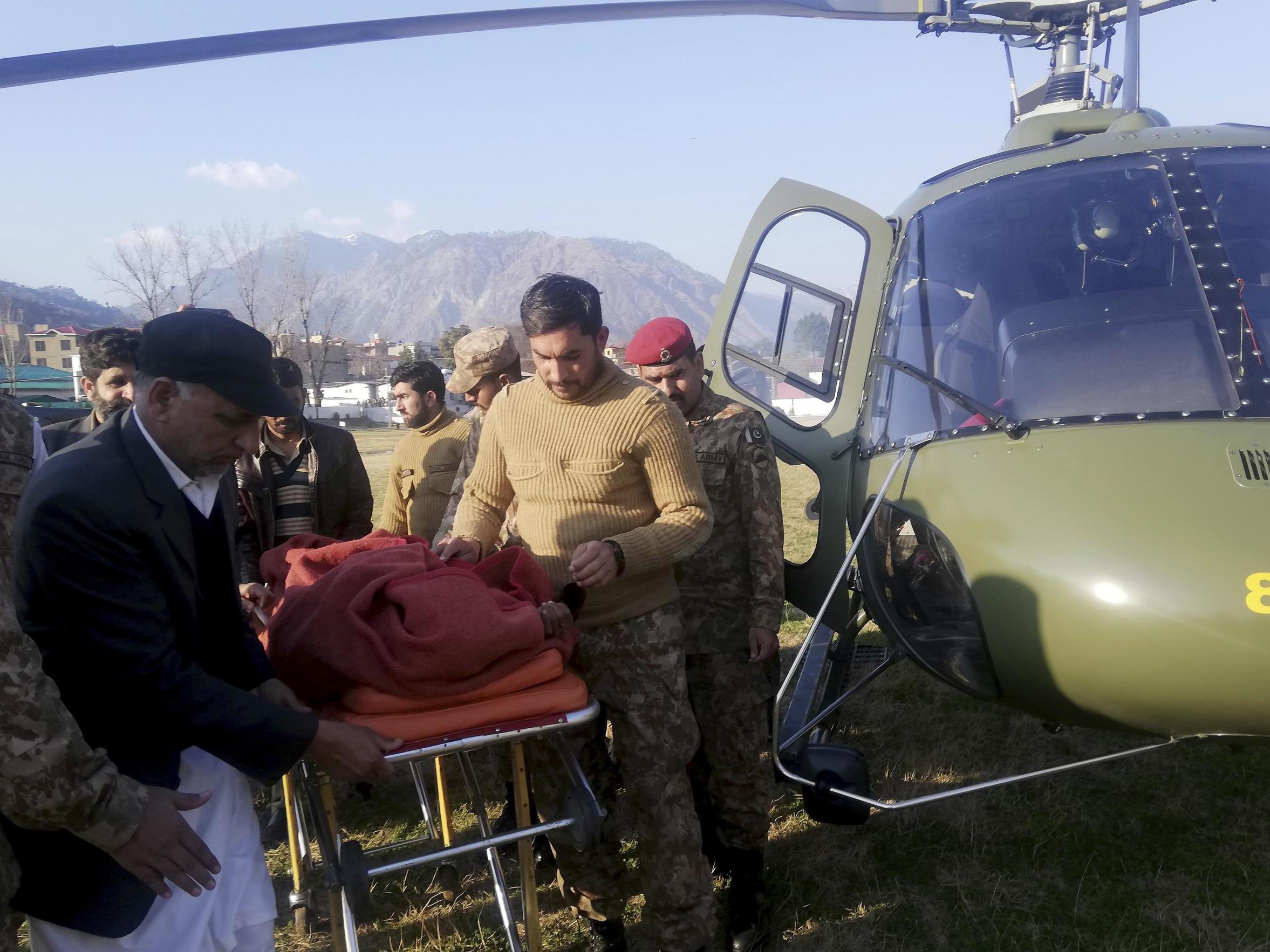Pakistan army soldiers transport an injured victim of an avalanche at a helipad in Muzaffarabad Jan 14 2020
