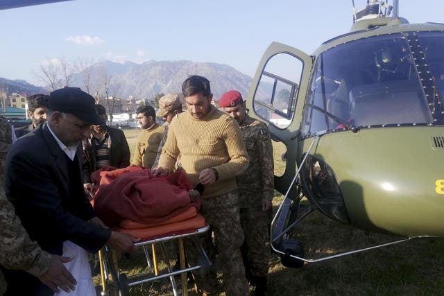 Pakistan army soldiers transport an injured victim of an avalanche at a helipad in Muzaffarabad Jan 14 2020