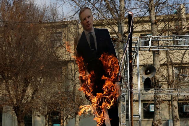 Pro-government protesters set fire to a life size cut out of Britain's ambassador to Tehran