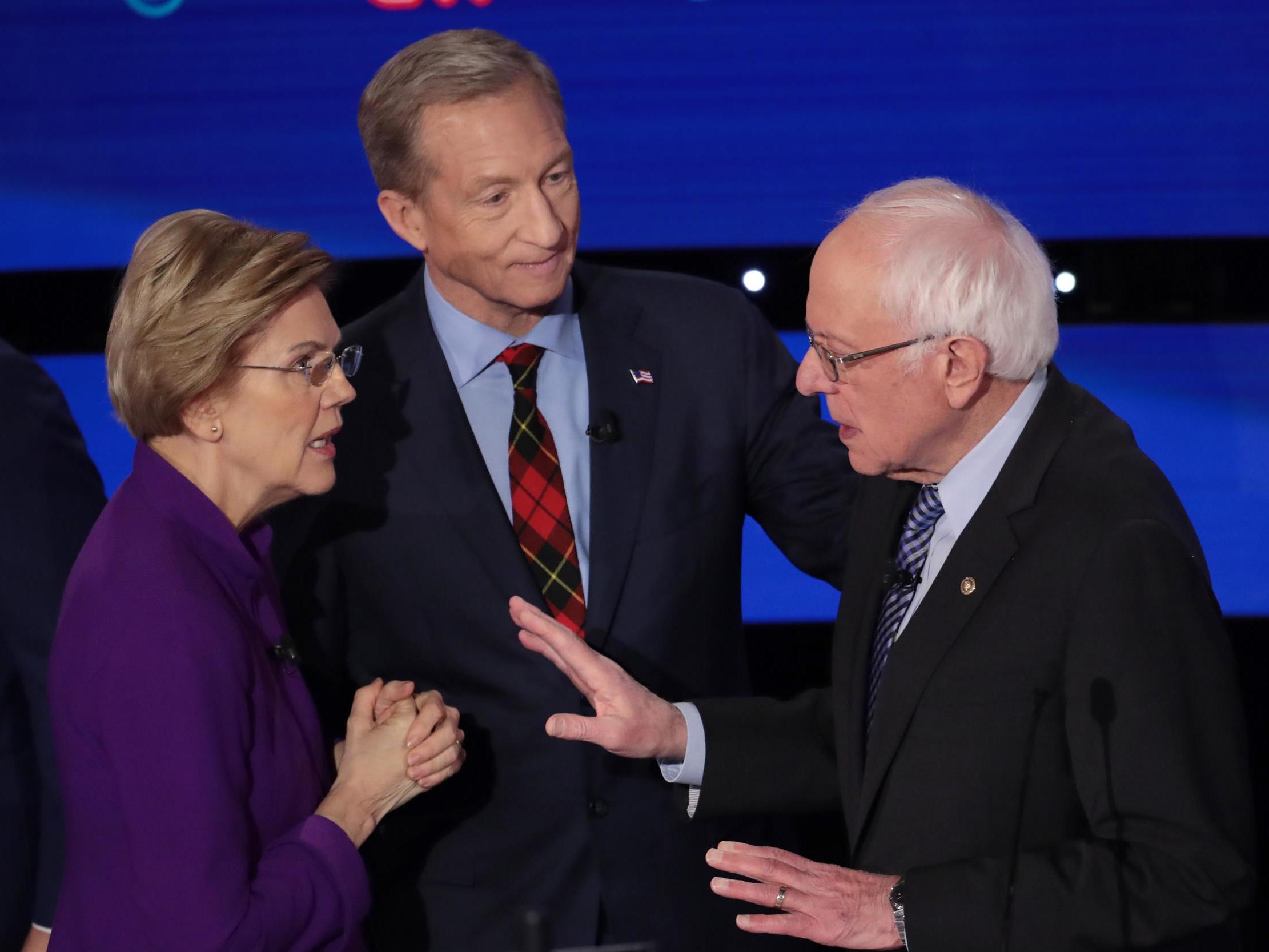 Elizabeth Warren and Bernie Sanders speak as Tom Steyer looks on after the Democratic presidential primary debate in Des Moines