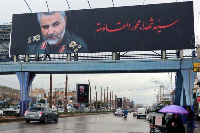 A woman holds an umbrella as she walks near a picture of late Iranian Major-General Qassem Soleimani, head of the elite Quds Force, in Beirut's suburbs, Lebanon, January 5, 2020. REUTERS/Aziz Taher