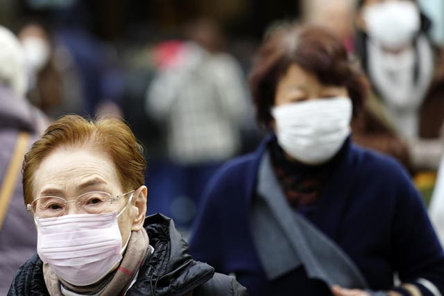 Pedestrians wear protective masks as they walk through a shopping district in Tokyo Thursday Jan 16 2020