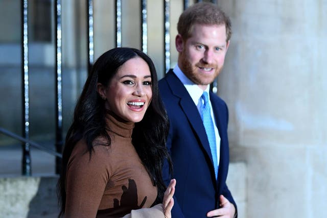 Prince Harry and Meghan react as they leave a visit
