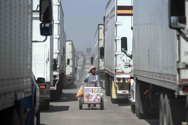 A street vendor sells ice cream to cargo trucks drivers lining up to cross to the United States at Otay commercial crossing port in Tijuana, Baja California state, on June 6, 2019