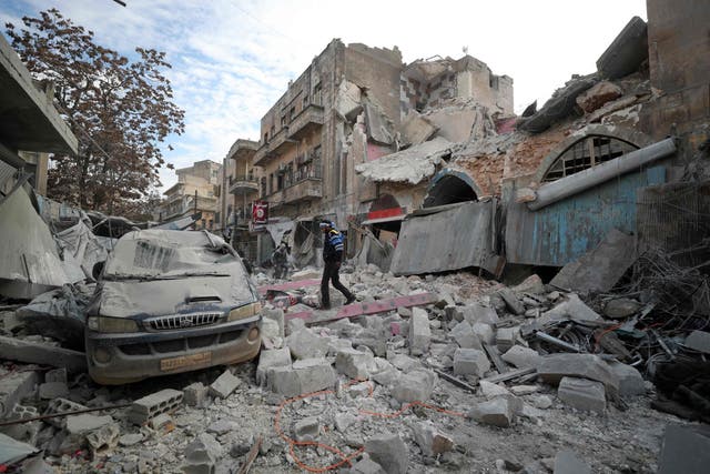 A man walks over the rubble of a building in Ariha following an airstrike