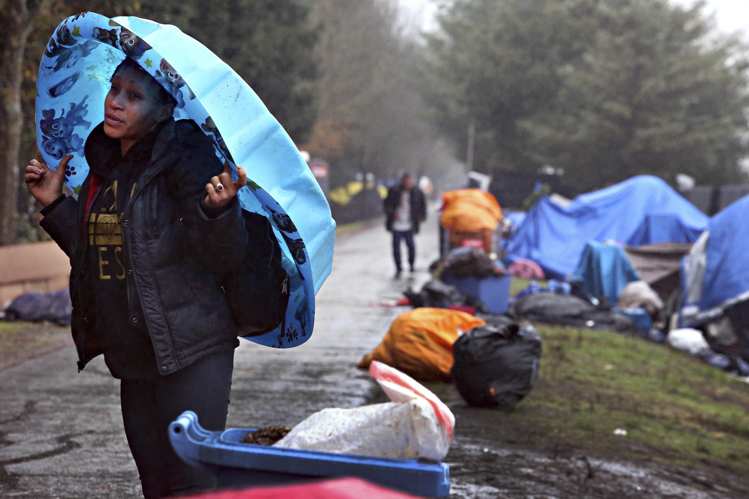 A resident takes cover from the rain