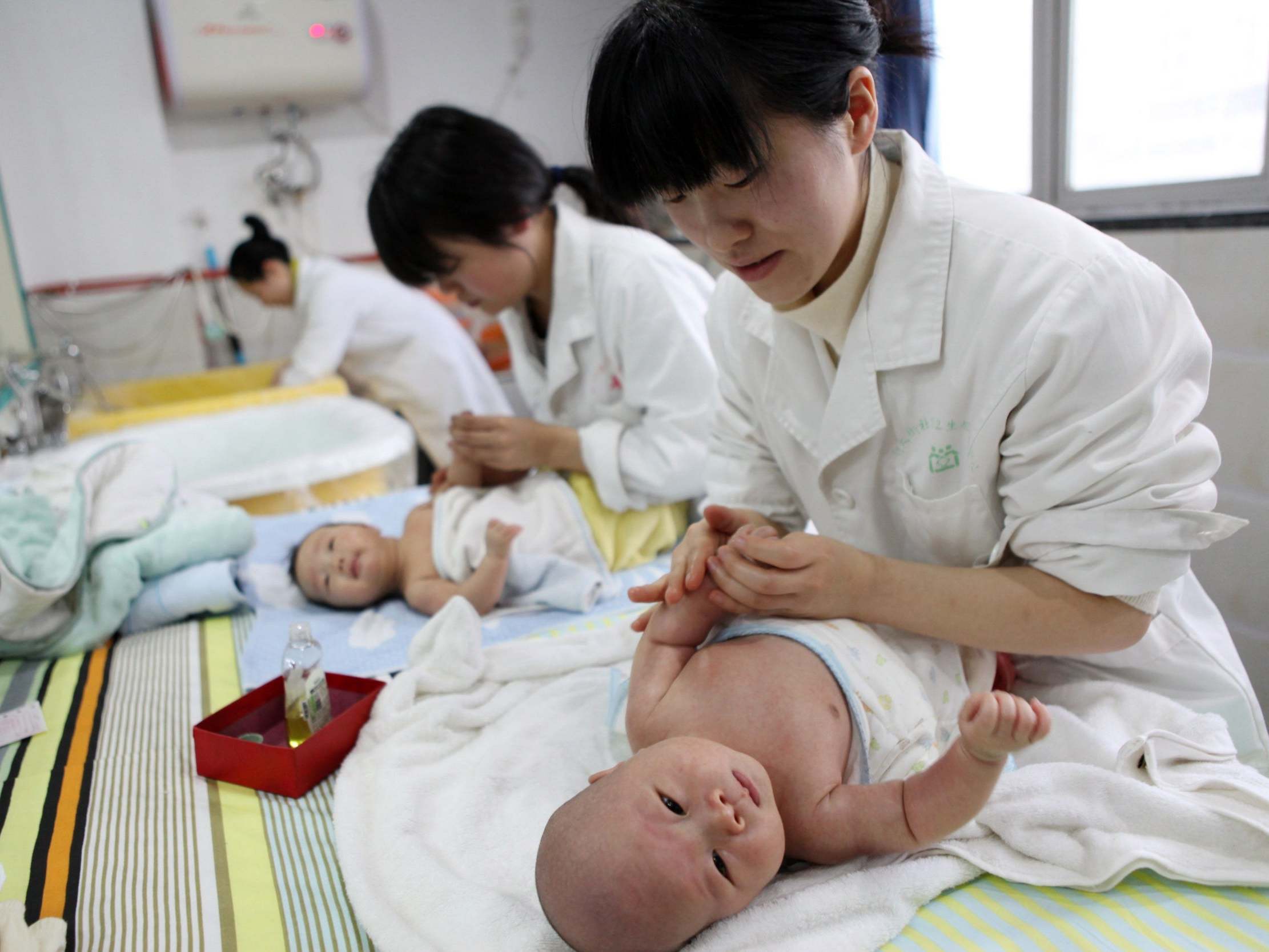 Nurses look after babies at an infant care centre in Yongquan, southwest China