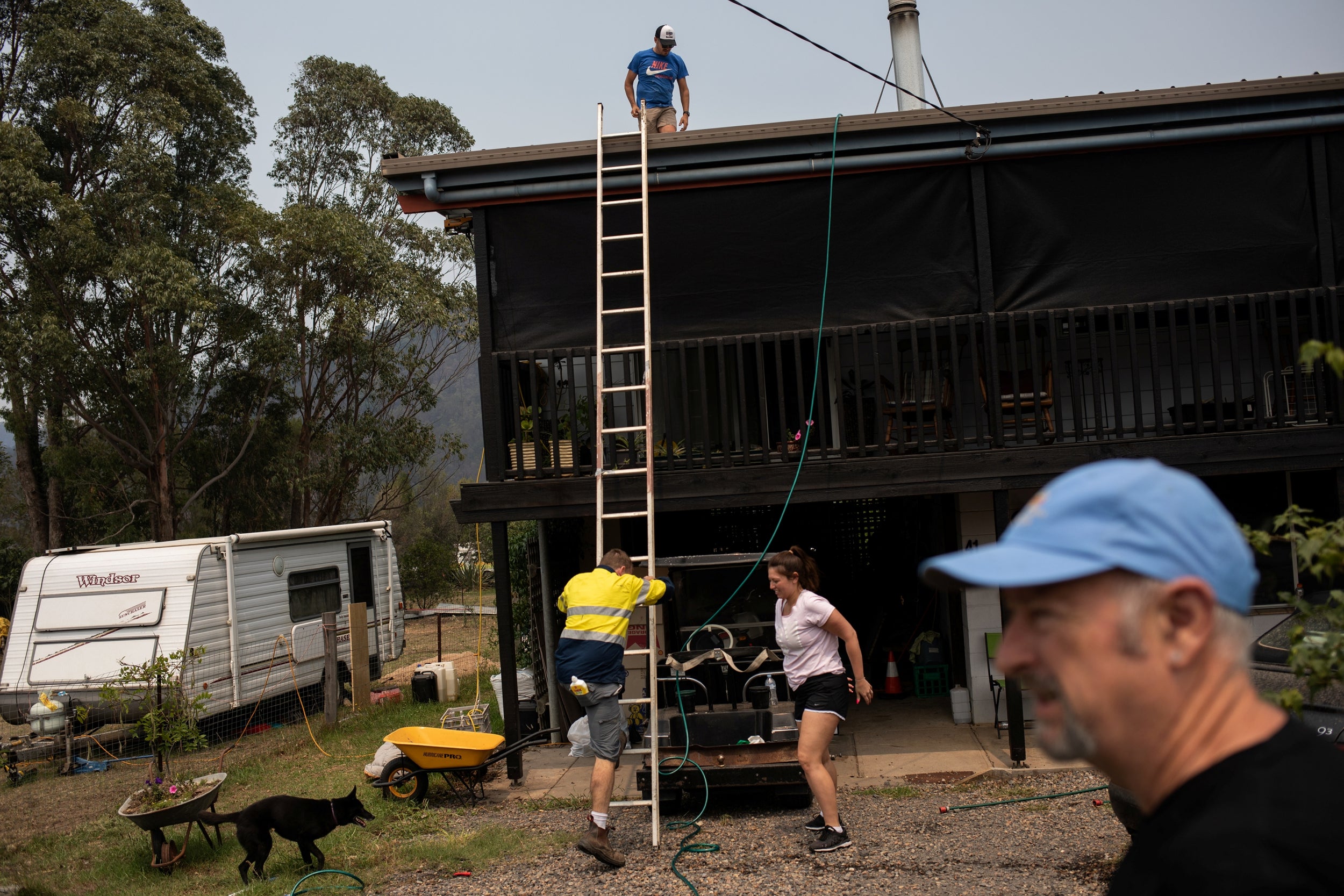 Community workers clean the solar panels on Peter Hisco’s house