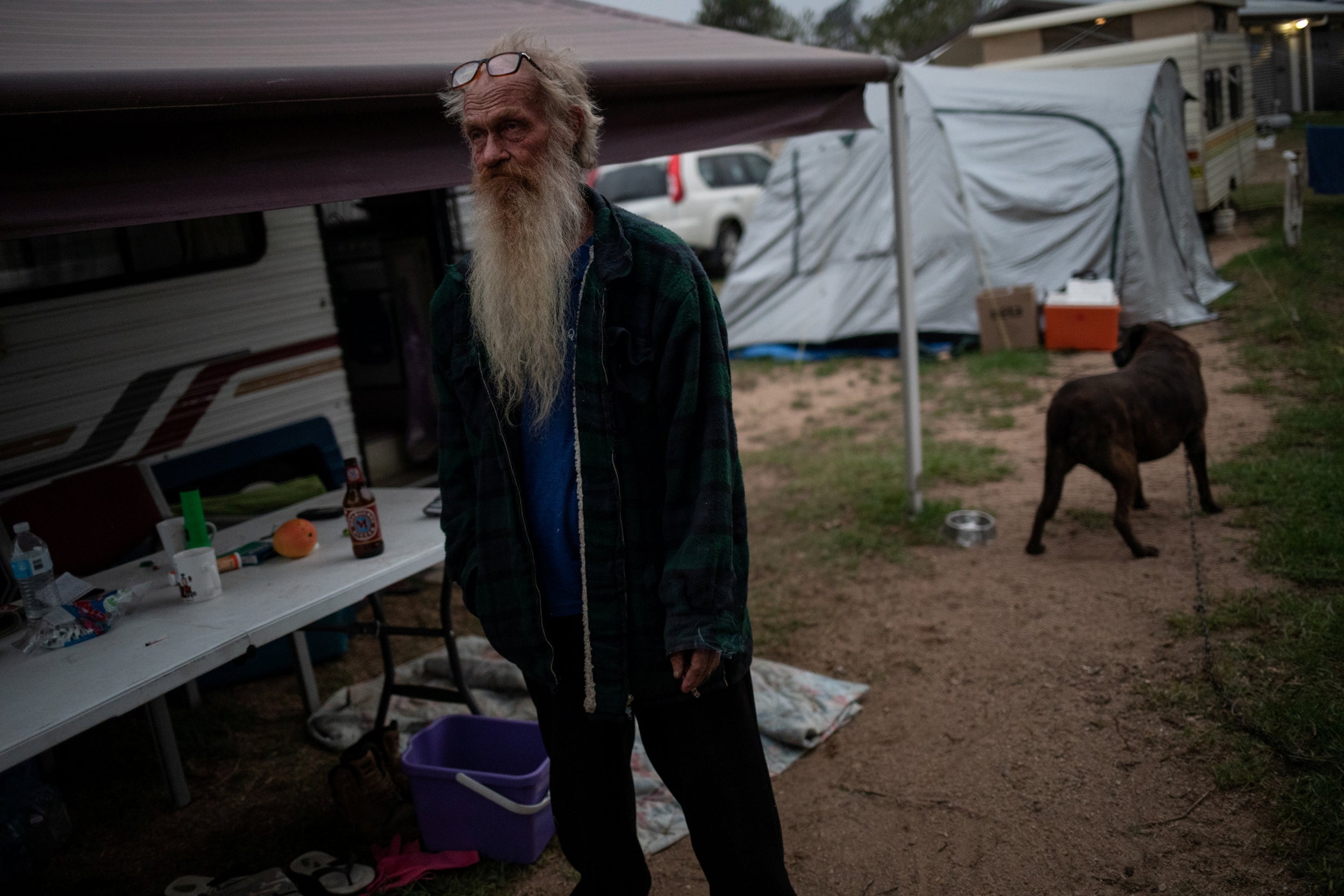 Rod Dunn stands outside the borrowed caravan he is now living in with his wife