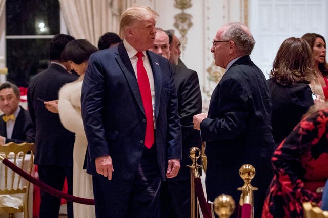 Donald Trump speaks to Alan Dershowitz as he arrives for a Christmas Eve dinner at Mar-a-Lago in Palm Beach, Florida, in 2019