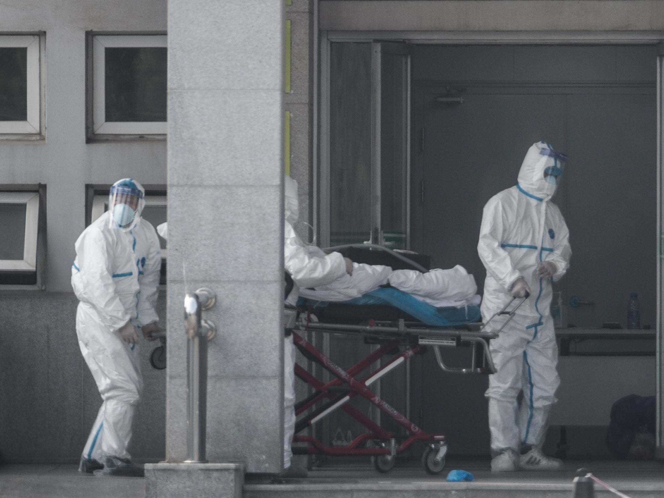 Medical staff carry a patient into the Jinyintan hospital, where patients infected with a new strain of Coronavirus identified as the cause of the Wuhan pneumonia outbreak are being treated