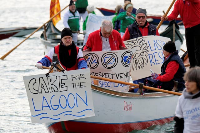 Venetian protesters hold placards during the demonstration against the damage caused by big ships