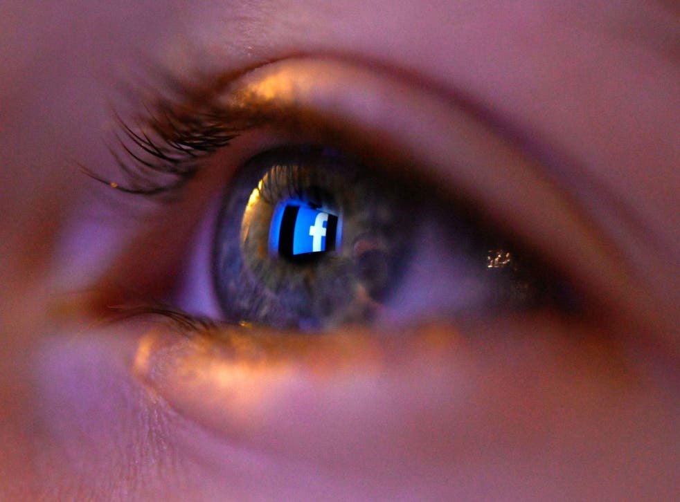 This illustration picture, taken on January 12, 2020 shows Facebook social network logo reflected on a eye in Rennes, western France