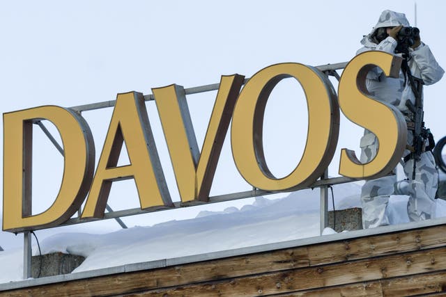 A police officer monitors the conference centre hosting the 2020 Davos summit - reportedly targeted by Russian spies - from an adjacent roof