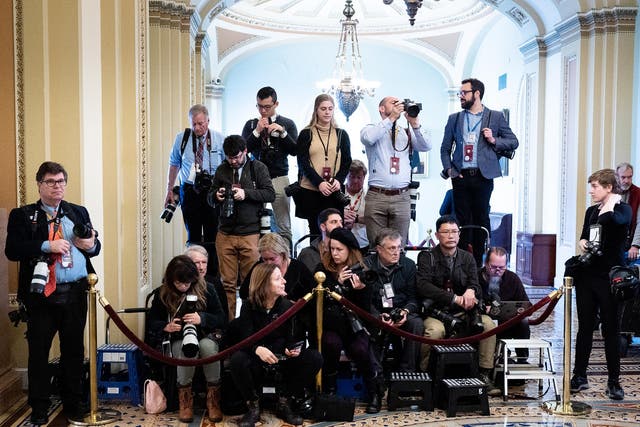 Press photographers covering the trial are confined to a small enclosure