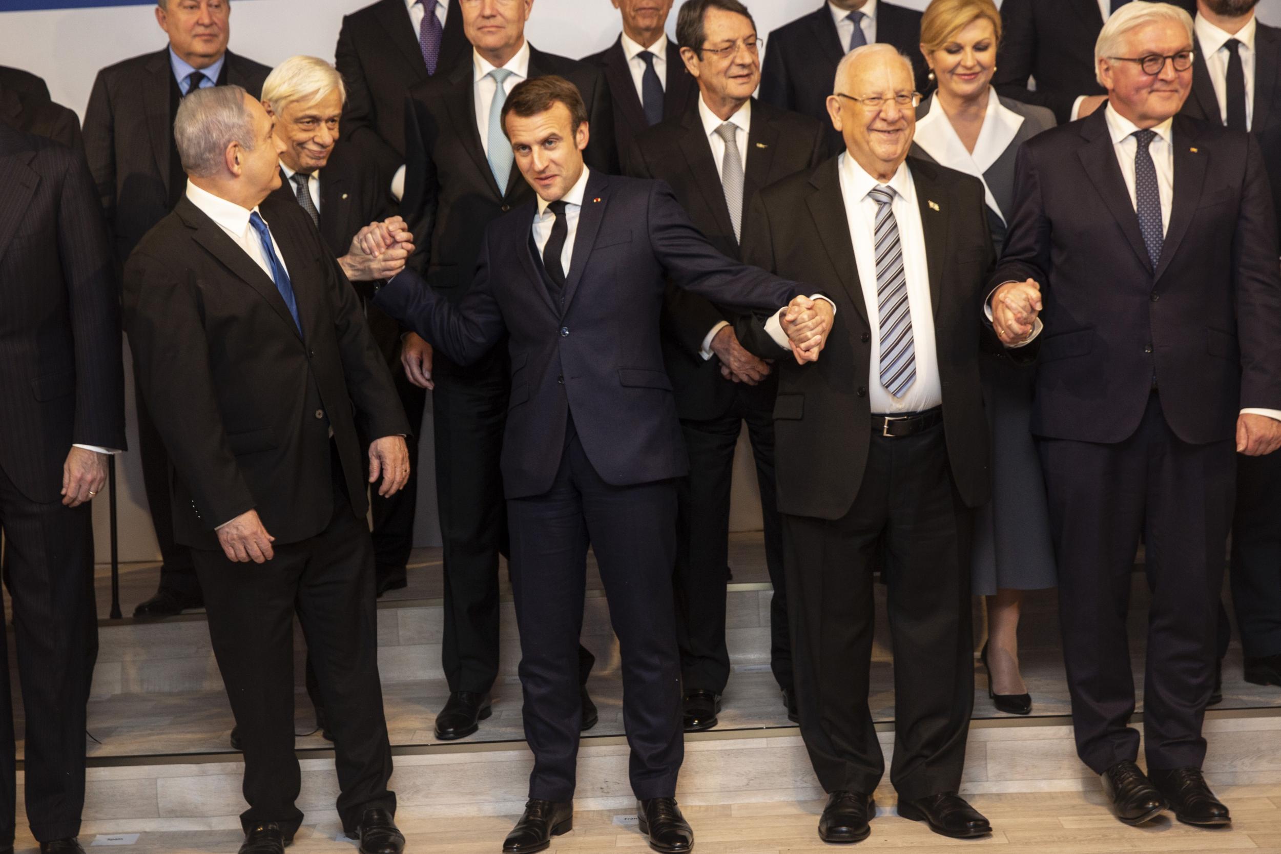 Israeli Prime Minister Benjamin Netanyahu (front L) looks behind him as he stands next to (L to R) French President Emmanuel Macron (front-2nd L), his Israeli counterpart Reuven Rivlin, and German counterpart Frank-Walter Steinmeier, as they pose with other heads of state