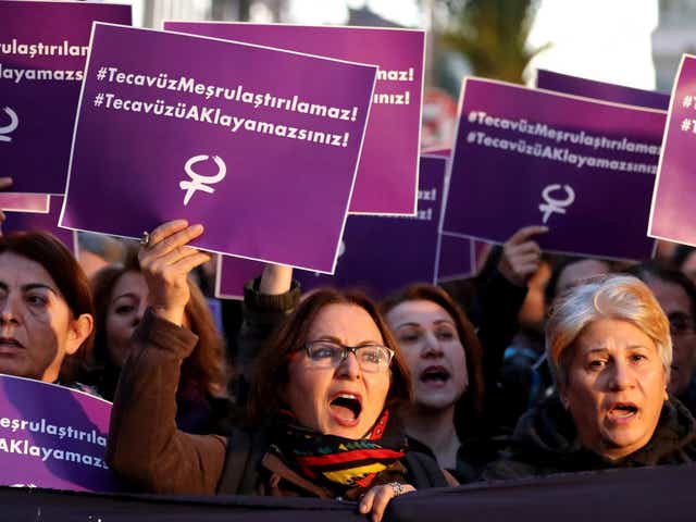 Turkish female protesters shout slogans against the government while holding placards reading ‘Rape cannot be legalised’