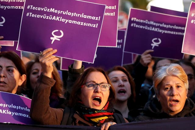 Turkish female protesters shout slogans against the government while holding placards reading ‘Rape cannot be legalised’