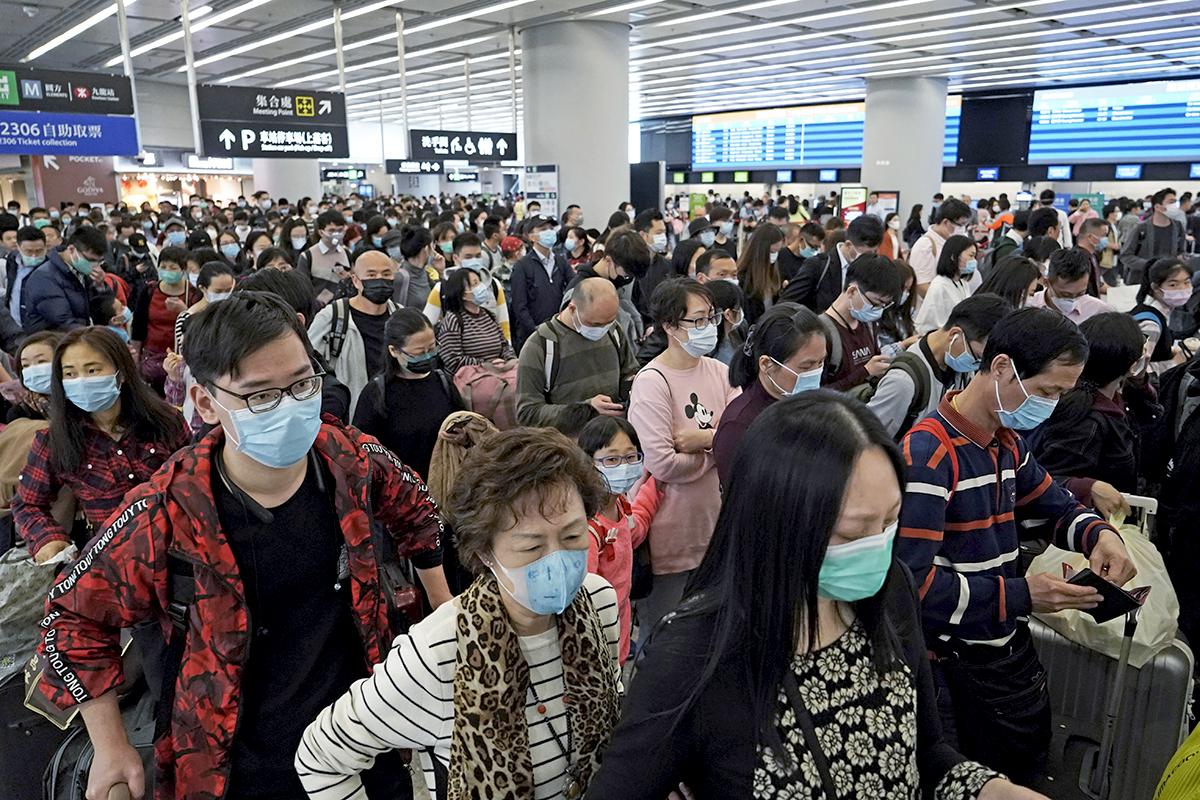 Passengers wear masks at the departure hall of a train station in Hong Kong