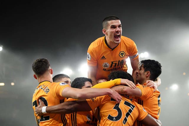 Conor Coady of Wolverhampton Wanderers jumps on his teammates as they celebrate Raul Jimenez scoring