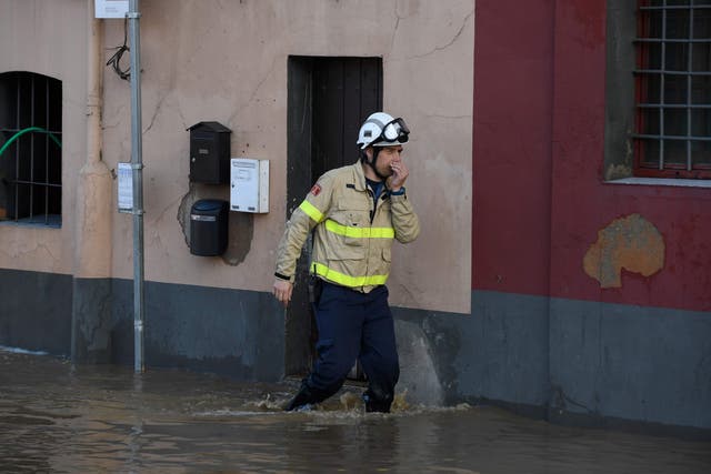 A fireman walks on a flooded street in Sarria de Ter on January 23 as storm Gloria batters Spanish eastern coast