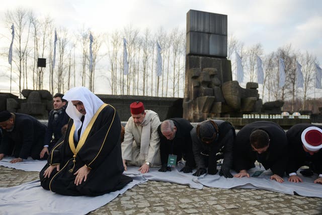 Muslim faith leaders perform Islamic prayers during a visit to Auschwitz