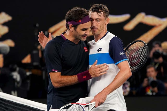 Roger Federer and John Millman greet each other at the net