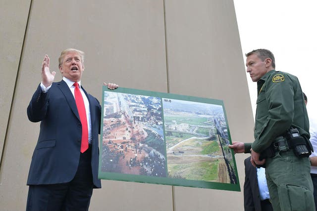 Mr Trump and Mr Scott with images of the border wall prototypes