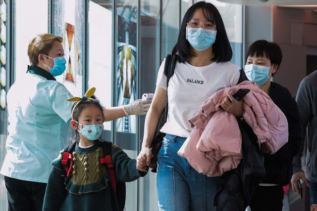 A health officer  screens arriving passengers from China at Changi International airport in Singapore